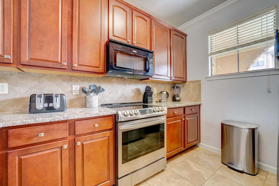 Kitchen with stainless steel appliances and warm wood cabinetry.