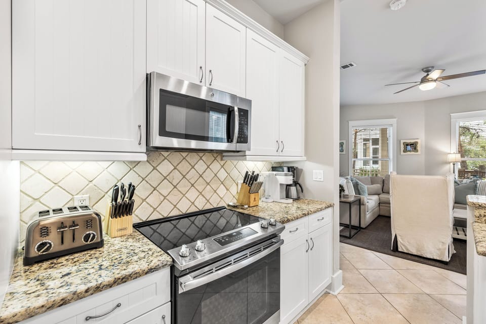 Fully stocked kitchen with stainless steel appliances & granite countertops.