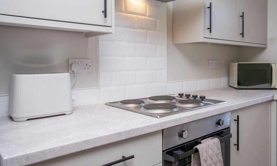 Clean and functional cooking space with toaster and microwave provided.