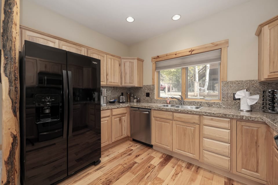 Your fully-equipped kitchen features warm wood cabinets, granite counters, and modern appliances for home-cooked meals.
