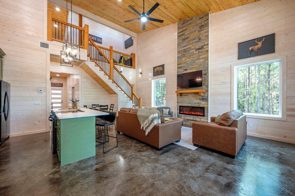 Bight open living area with Smart TV, electric fireplace, and leather seating
