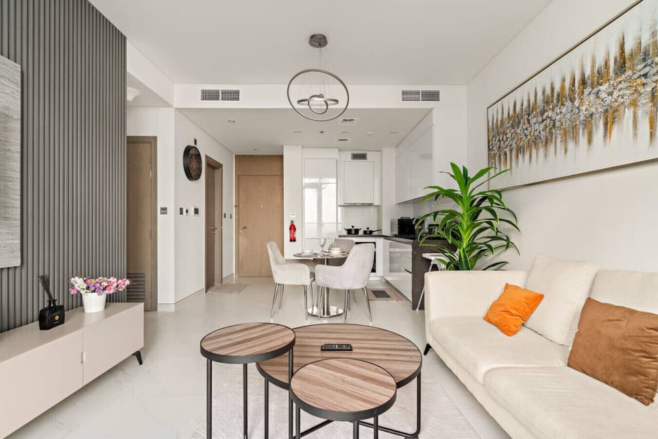 Sleek open-plan living with modern kitchen, chic art, and wood accents.