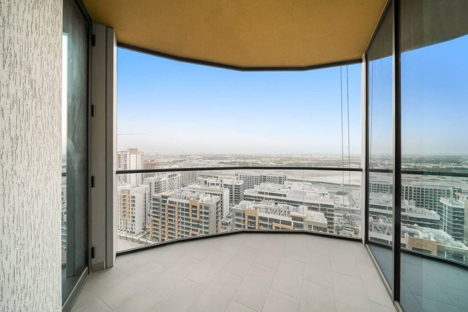 Spacious balcony with glass railing offering panoramic city skyline views.