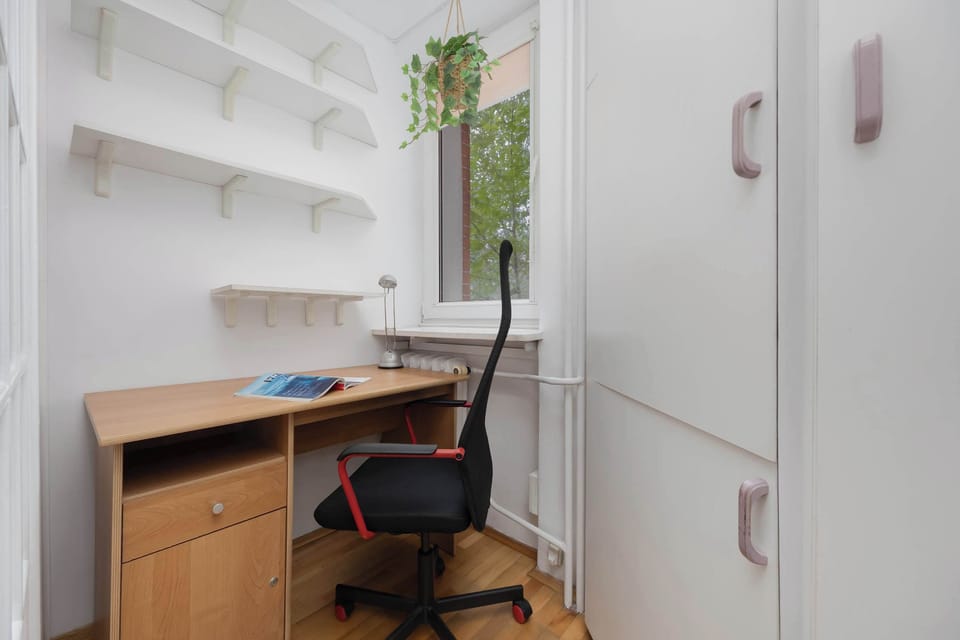 A small office corner with a desk and shelves provides a comfortable spot for remote work or studying.
