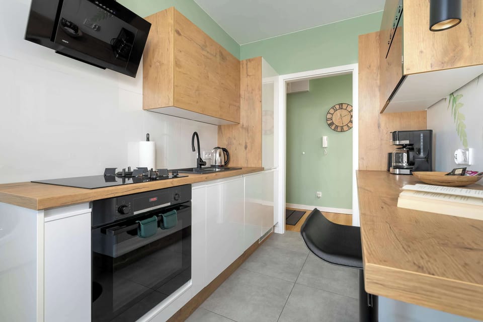 A kitchen view with white cabinetry, black appliances, and a breakfast bar.