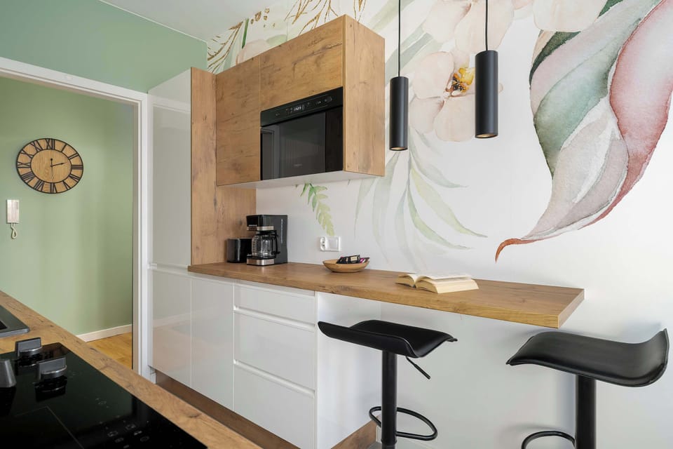 A different angle of the kitchen highlighting the bar stools and countertop.