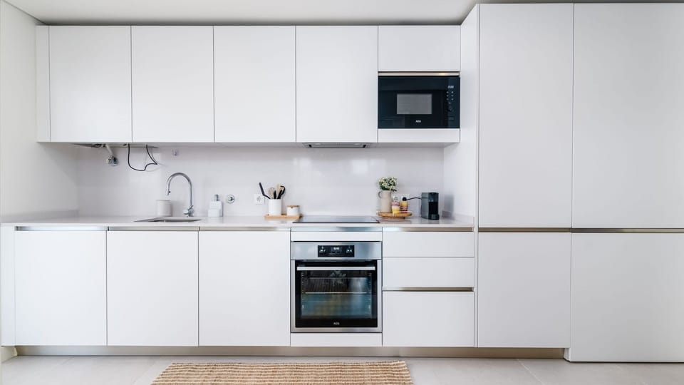 A sleek, fully equipped kitchen with modern appliances and a minimalist design, making it easy to prepare meals and enjoy a comfortable stay in Miraflores. #ModernKitchen #FullyEquipped  #CityBreak  #TravelPortugal #Portugal #PT #Oeiras