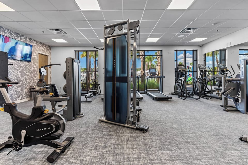 Step into this bright fitness center, where large windows invite natural light and offer vibrant views. Equipped with modern machines and ample space, this is the ideal spot to maintain your routine while enjoying your stay.