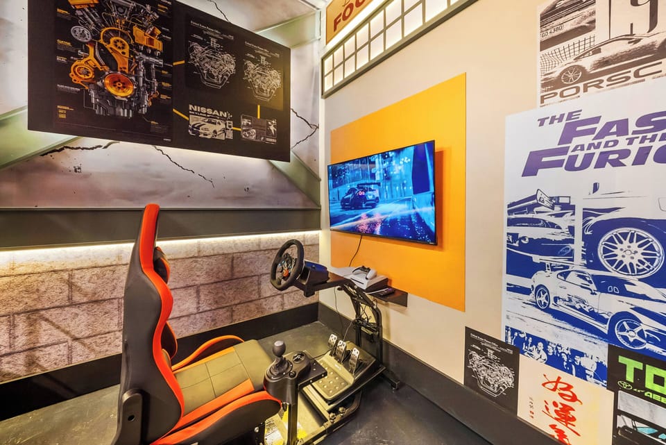 Experience the thrill of racing in our gaming corner, featuring a sleek racing seat and immersive setup. With vibrant wall graphics and ambient lighting, it creates the perfect atmosphere for an unforgettable time!