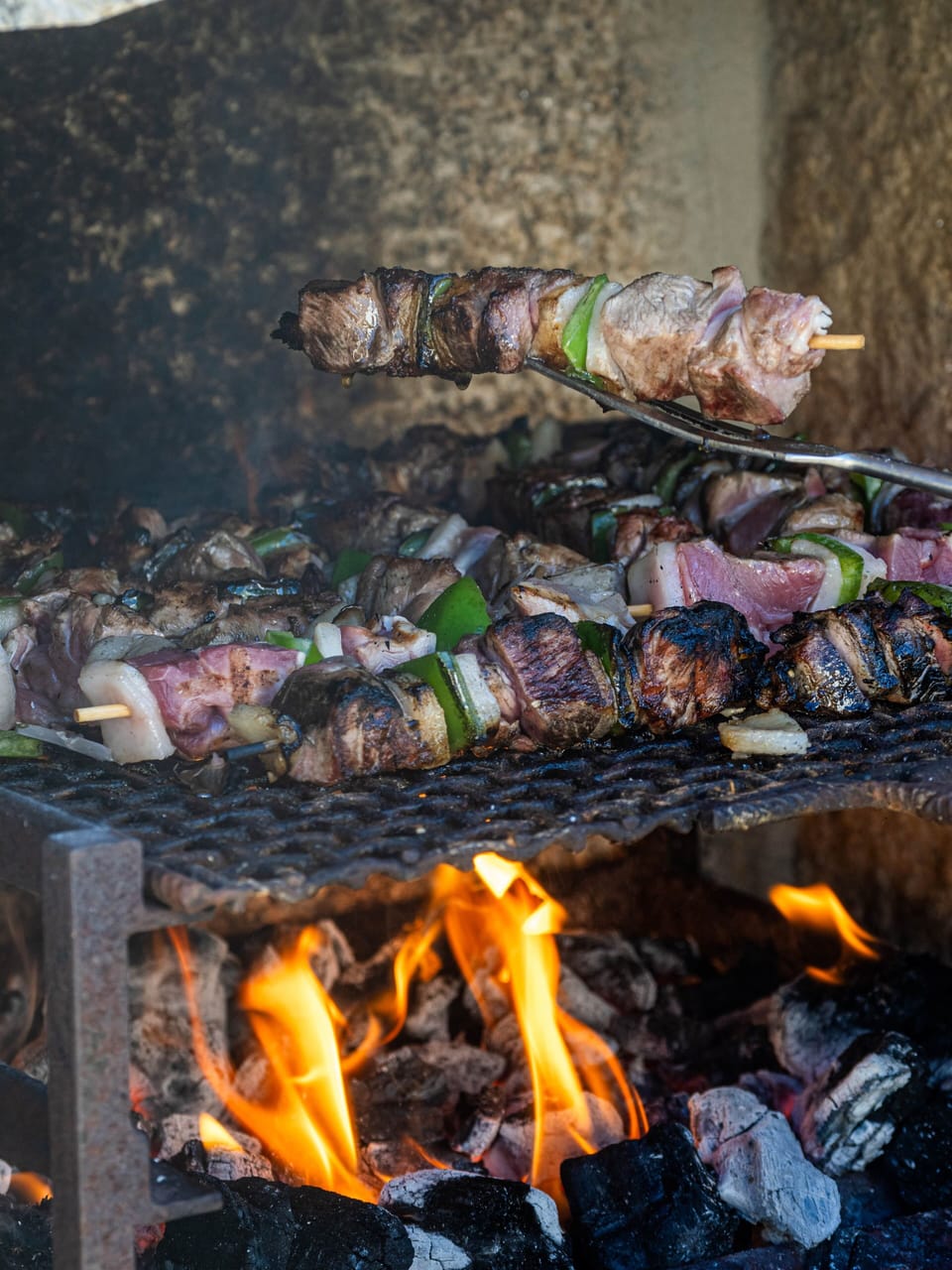 The charcoal grill in action, perfect for preparing delicious local meats and vegetables.