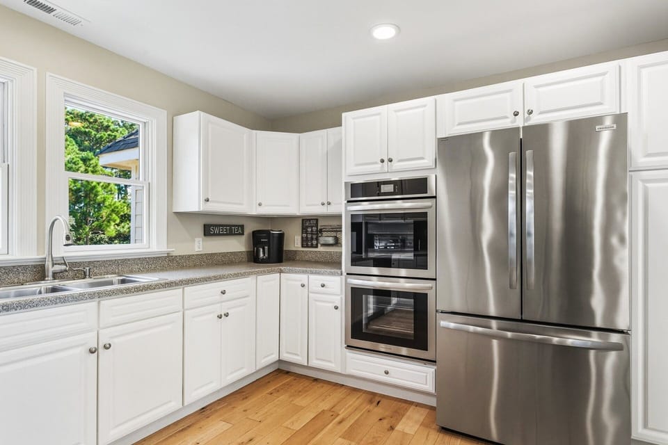 The kitchen includes counter seating, double ovens, and modern appliances, making meal prep effortless for large families or groups.