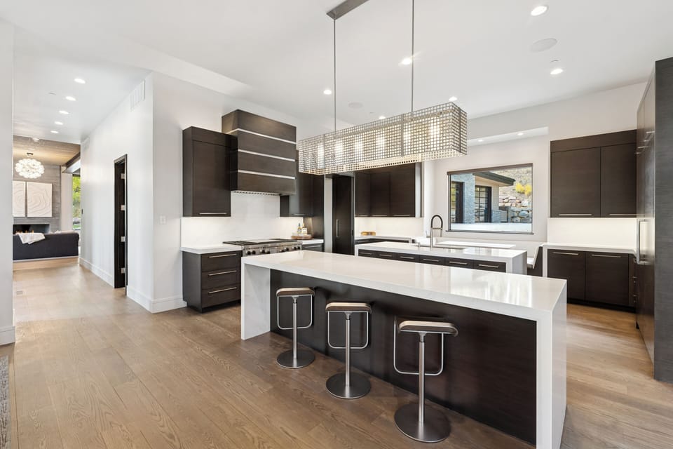 Sleek kitchen with waterfall island, bar seating, and pendant lighting