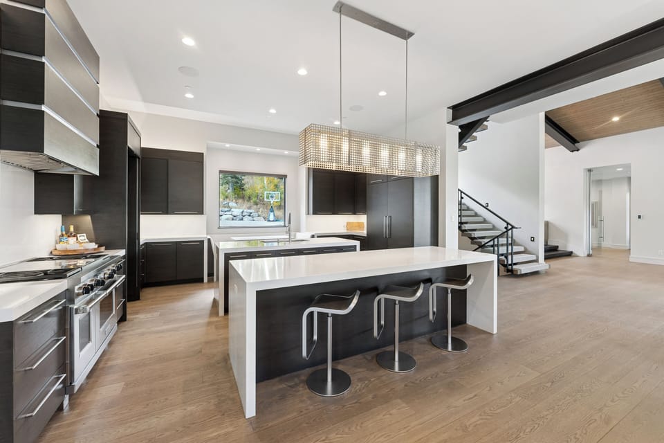 Spacious modern kitchen with large waterfall island, pendant lighting, and open layout