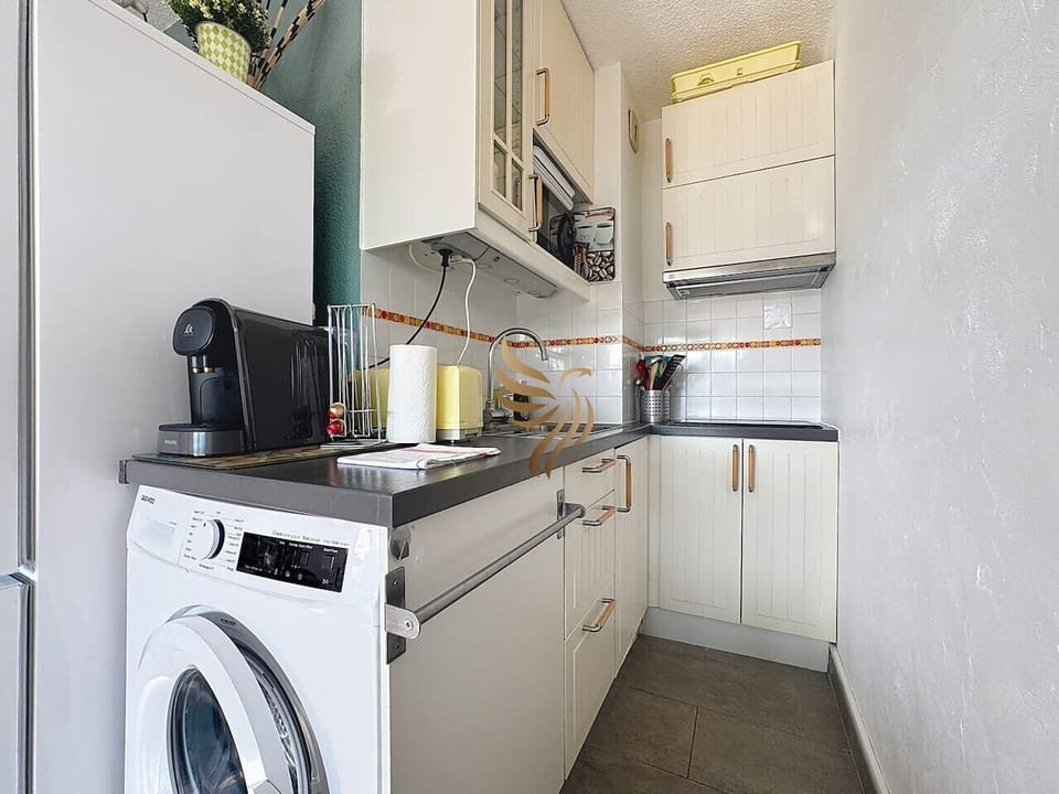 Cuisine équipée, fonctionnelle, avec réfrigirateur, plaques, micro-ondes, lave-linge et machine à café.