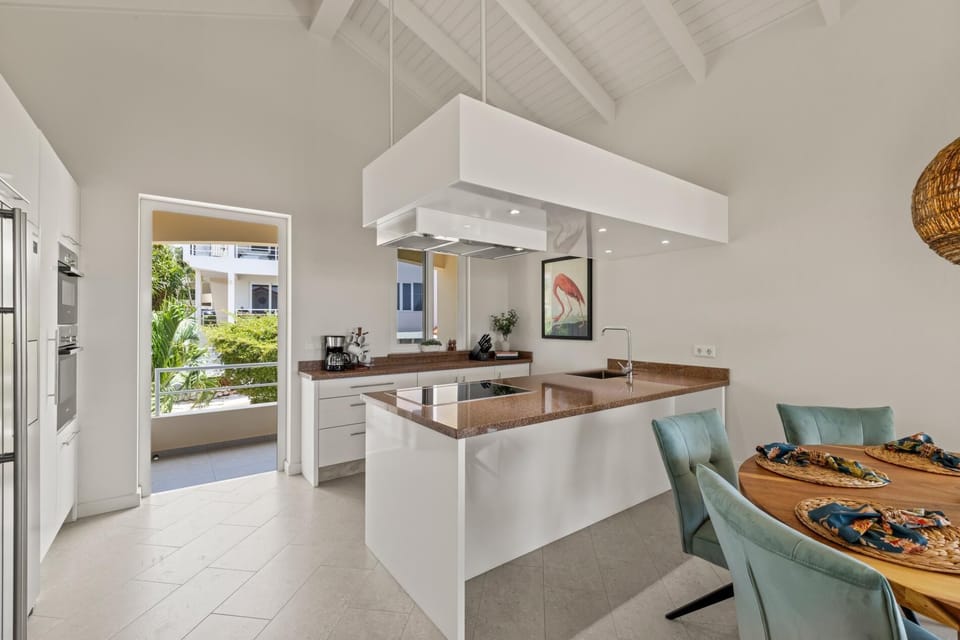 Bright, modern kitchen with sleek counters and direct access to the terrace.