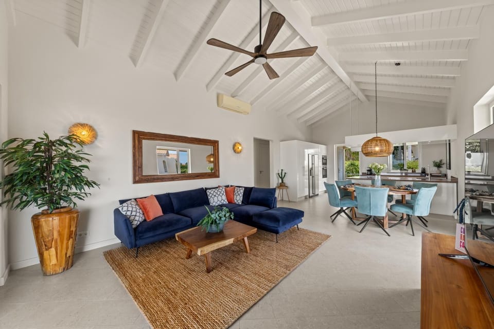 Bright living room with vaulted ceilings, cozy seating, and natural light.