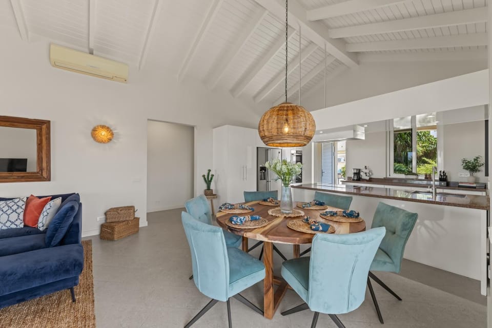 Open dining area with natural textures and high ceilings for island elegance.