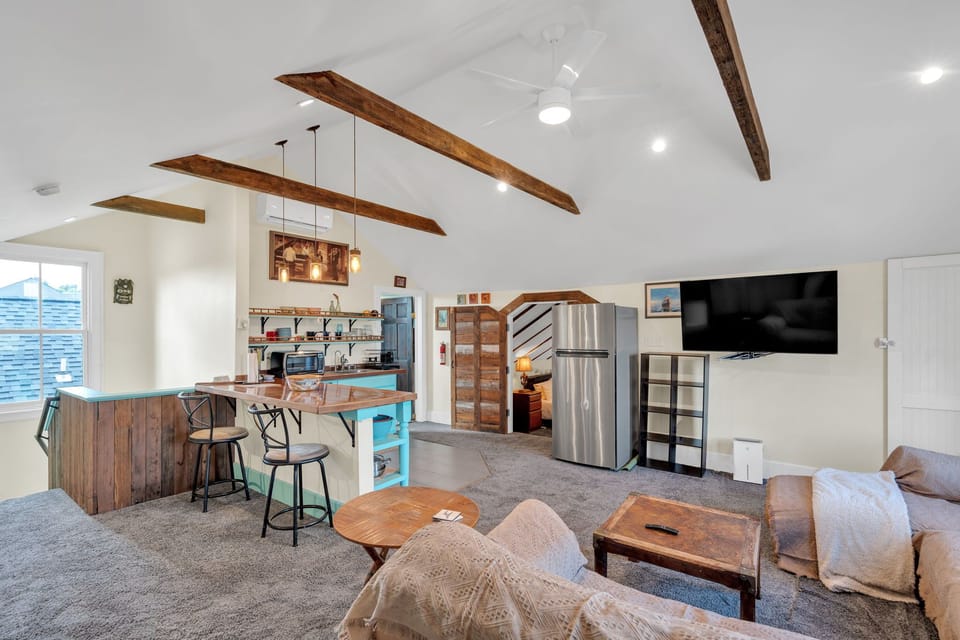 Open-concept living area w/ exposed beams & a bright, airy feel.
