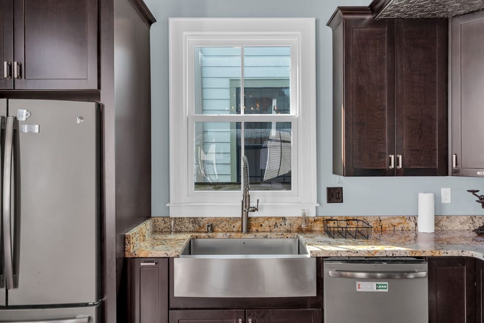 Bright bathroom w/ warm stone countertops & natural light.
