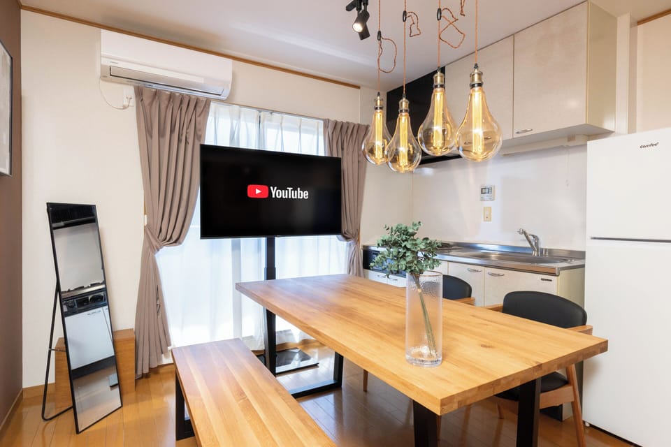Apartment, Balcony | Living area | 65-inch flat-screen TV with digital channels