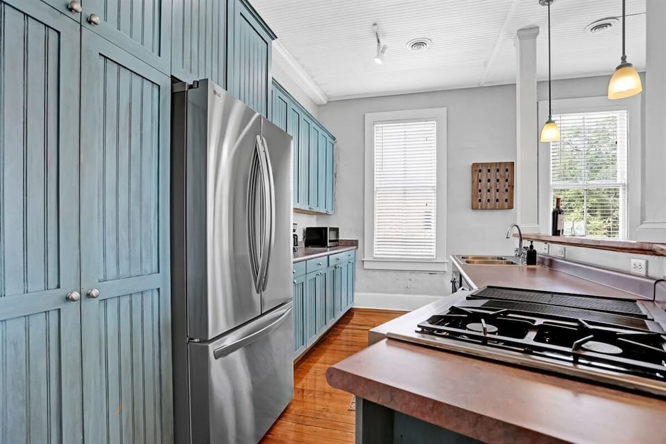 Bold blue cabinetry, stainless appliances, and room to gather around the island.