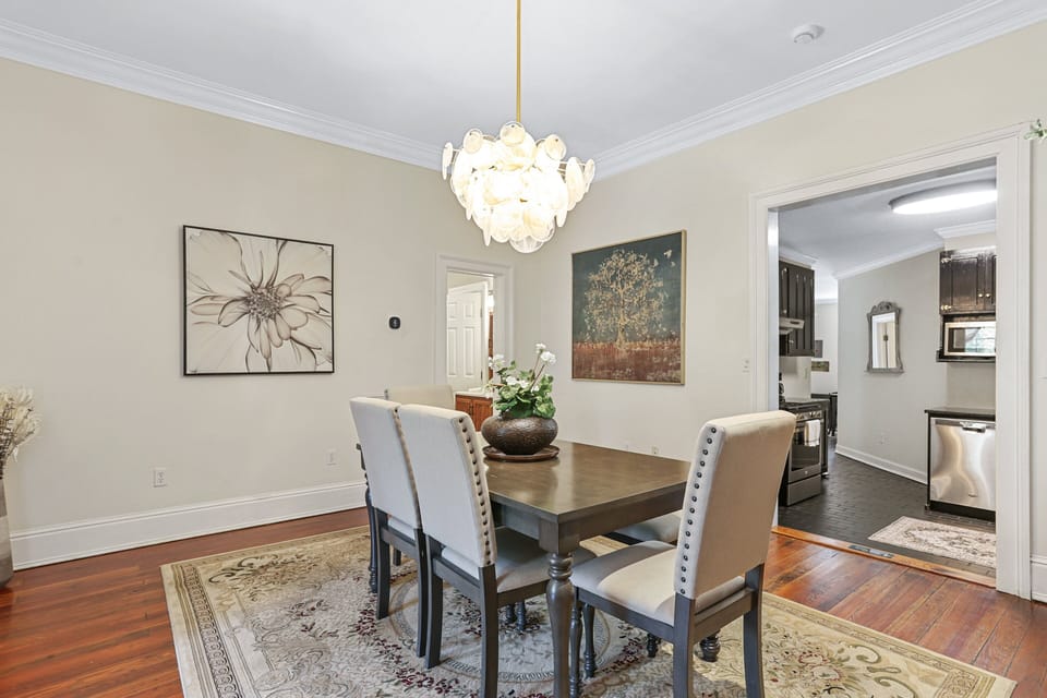 The main dining table features seating for six with a mix of chairs and a bench, creating a welcoming space for relaxed meals together.