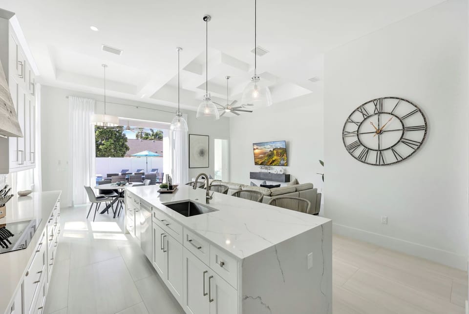 Stunning kitchen flows into dining with views out to the lanai — indoor-outdoor living at its best