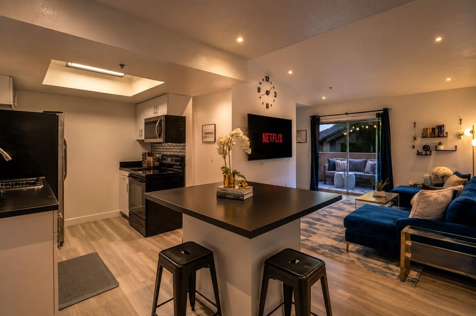 Modern open living space with patio access, breakfast bar, and cozy lounge