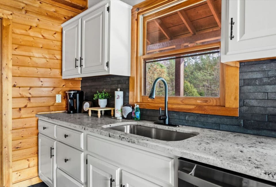 Enjoy a fully equipped kitchen with peaceful wooded views right from the sink, perfect for slow mornings and easy meal prep.