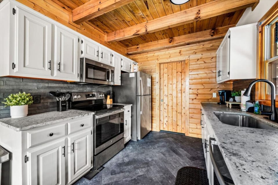 Cook together in this bright, updated kitchen with modern appliances, stone accents, and plenty of counter space to prep meals and gather around.