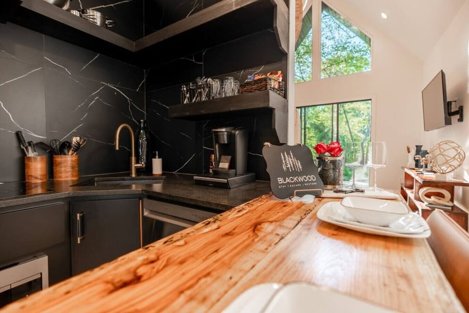 Fully equipped kitchen featuring a wood island, modern appliances, and clean design.