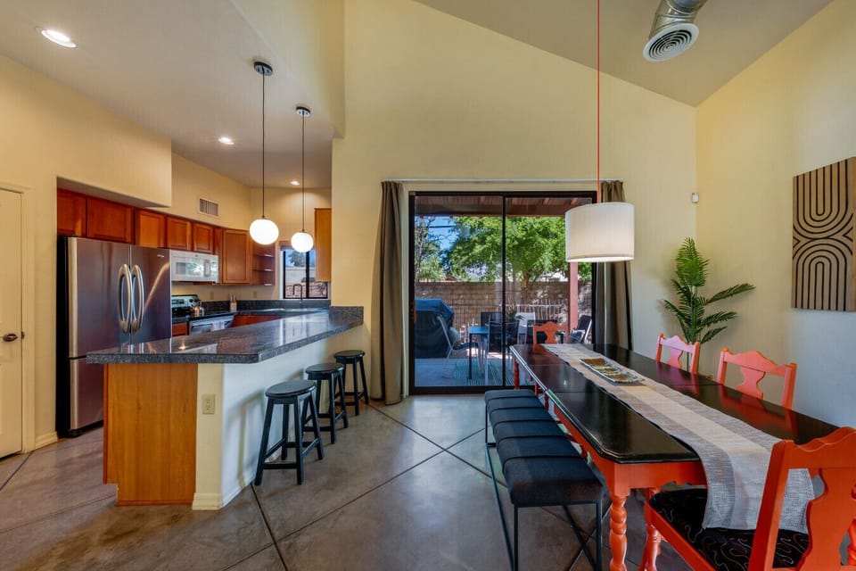 Fully stocked kitchen and dining space, both with views of the covered patio and fully fenced backyard
