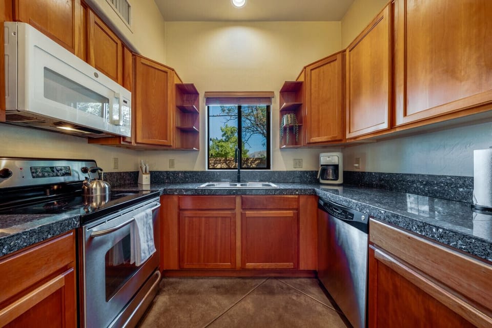 Bright, modern, and fully stocked kitchen with plenty of storage, stainless steel appliances, and granite counters