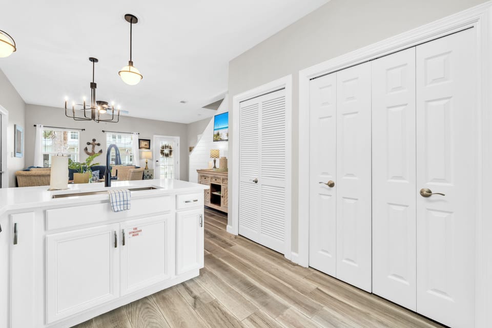 Your bright, modern kitchen awaits with pristine white cabinets, sleek countertops, and thoughtful storage solutions for all your vacation cooking needs.