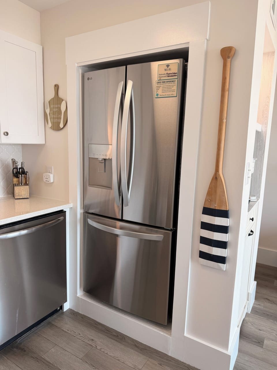 Sleek kitchen with French-door fridge, dishwasher, and whole-house water filtration system