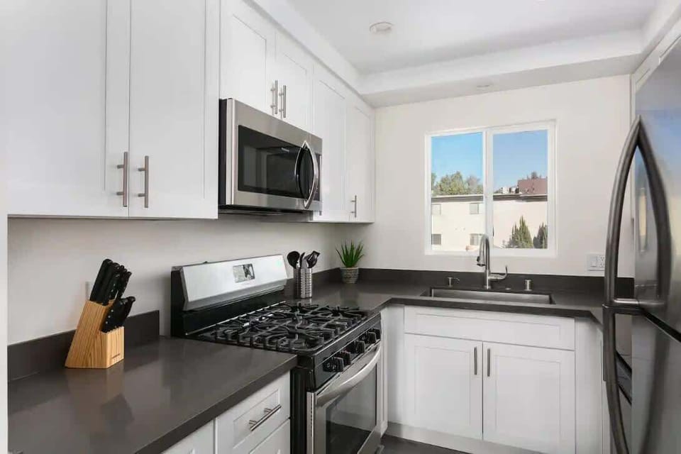Fully equipped modern kitchen with stainless steel appliances and lots of light