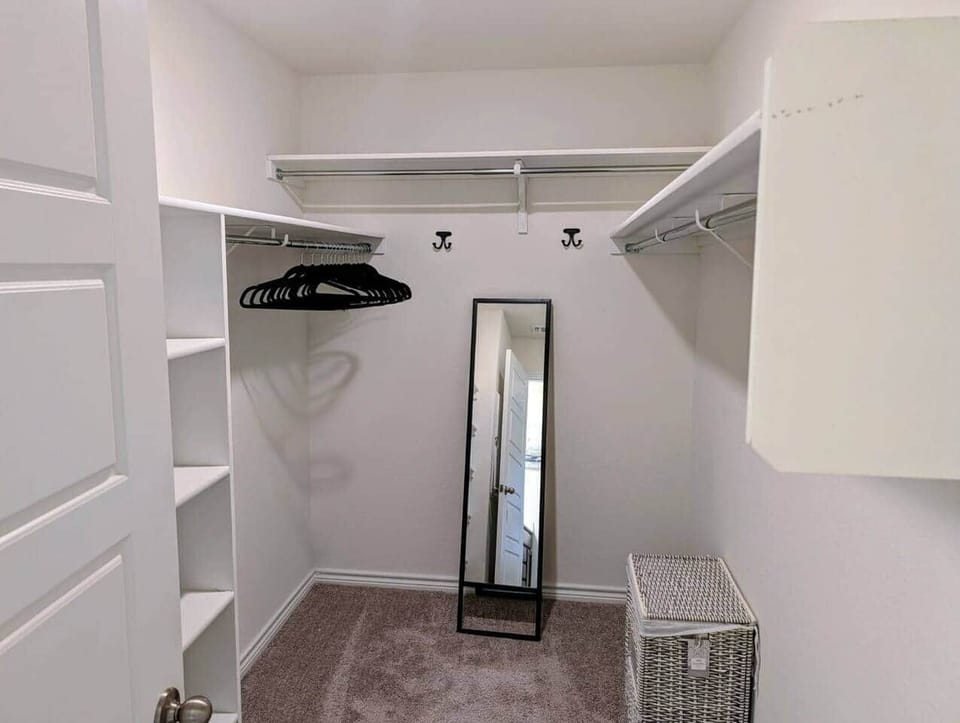 Huge walk in closet with hangers and full size mirror 