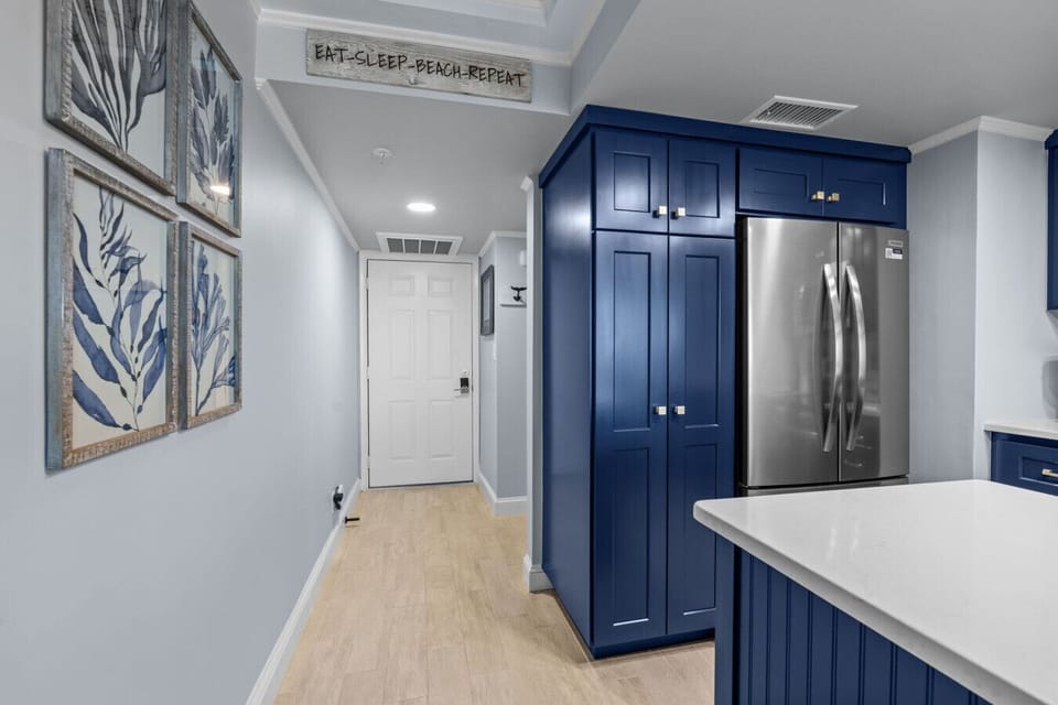 Kitchen Entrance – Stylish blue cabinetry and modern finishes set the tone.