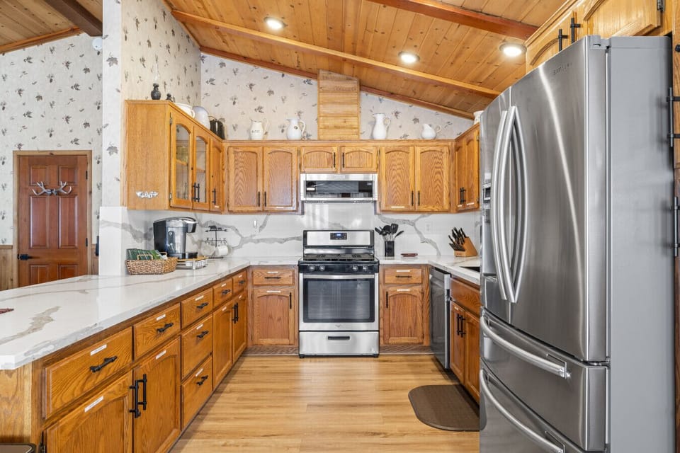 Fully equipped kitchen w/ stainless steel fridge, stove & plenty of cabinet storage.