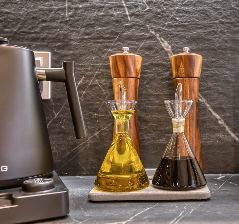 Kitchen details featuring a gooseneck kettle and high-quality olive oil, balsamic, and seasonings.