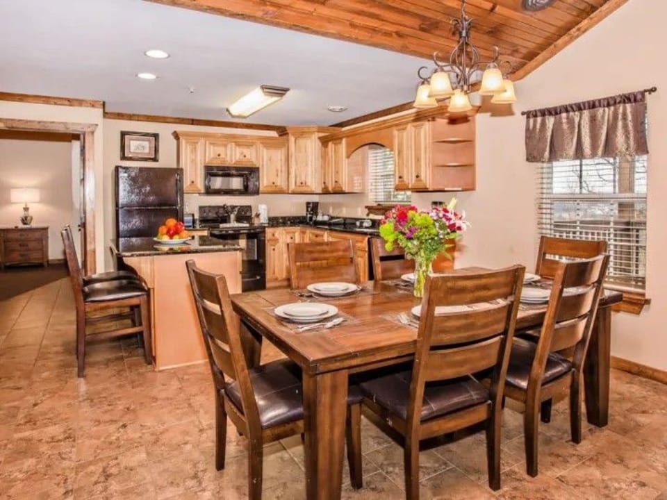 Dining room with wooden furniture and window views.