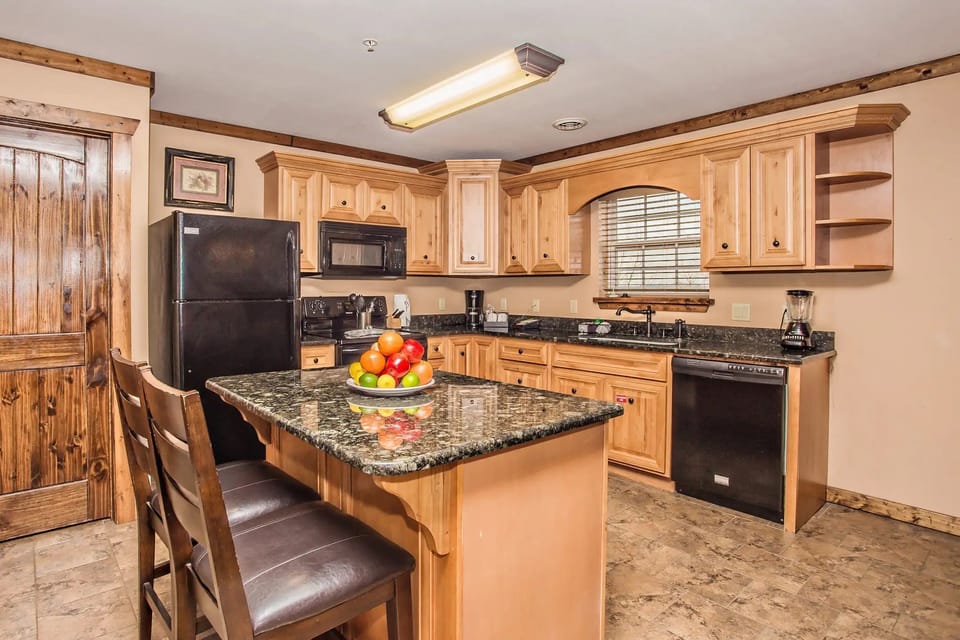 Kitchen and dining space with breakfast island and wooden cabinetry.