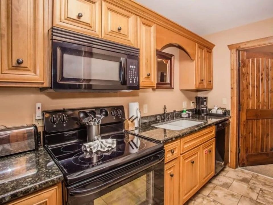 Kitchen with black appliances, wooden cabinets, and ample counter space.