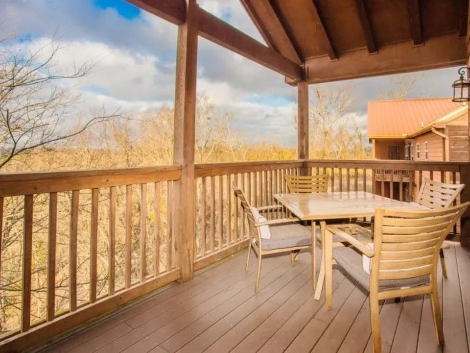 Private balcony with outdoor seating and mountain or wooded views.