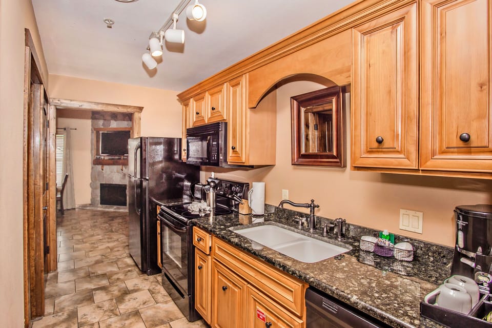 Kitchen with wood cabinetry, granite counters, and modern appliances.