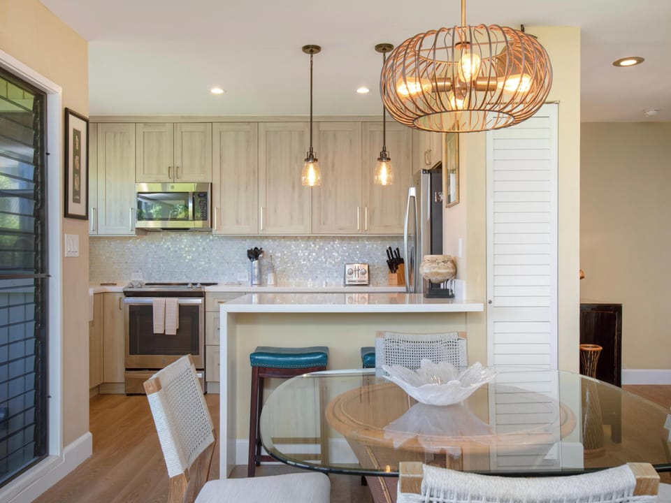Gather around this bright, open kitchen and dining space where stylish pendant lighting and coastal touches create the perfect setting for your morning coffee or shared meals together.