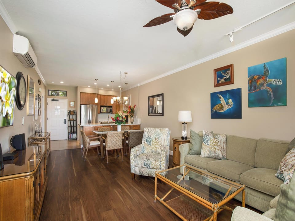 Settle into your coastal-themed living space with tropical flair and an open layout. The ceiling fan keeps you cool while you relax on the plush sofa or gather around the dining table just steps from your fully equipped kitchen.
