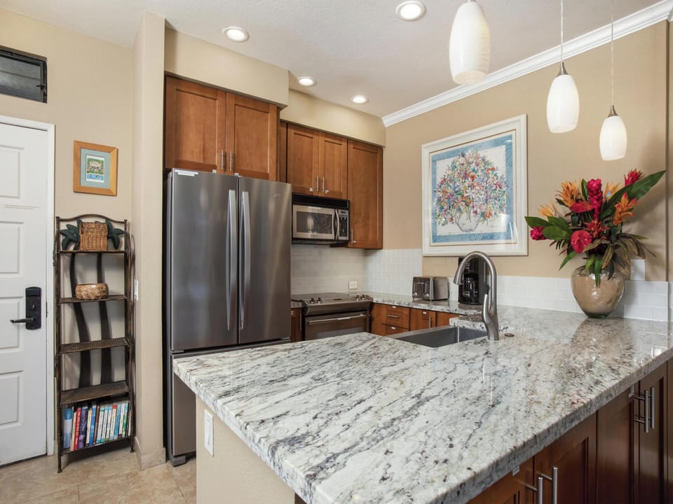 Your kitchen features sleek granite countertops, stainless steel appliances, and warm wood cabinetry—perfect for preparing meals or gathering over morning coffee in this inviting space.