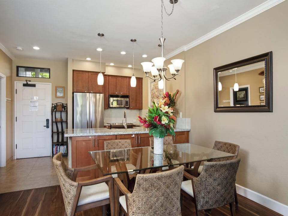 Gather around the elegant glass dining table, where warm lighting and an open layout create the perfect setting for your group meals and memorable conversations.
