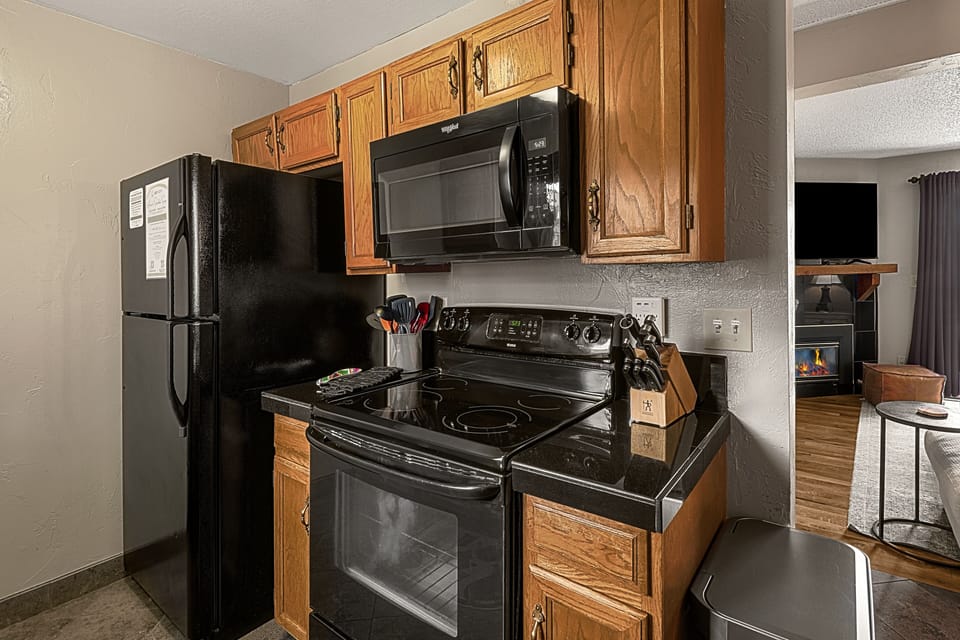 Kitchen with microwave, stove, oven and full fridge